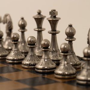 Metaliniai šachmatai su odos pakaitalo lenta ir šaškėmis